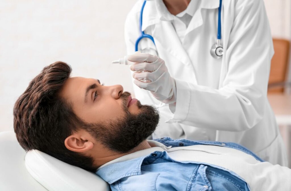 Man receiving eye drops during an eye exam.